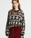 Woman wearing ModCloth Fair Isle Halloween sweater in Creepin' It Cozy featuring ghosts, skulls, bats, spiders, and gravestone knit motifs.