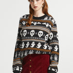 Woman wearing ModCloth Fair Isle Halloween sweater in Creepin' It Cozy featuring ghosts, skulls, bats, spiders, and gravestone knit motifs.