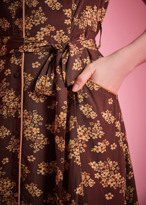 Front slant pocket detail on brown floral dress with removable self-tie belt