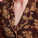 Close-up of rounded collar with contrast piping on brown floral viscose dress