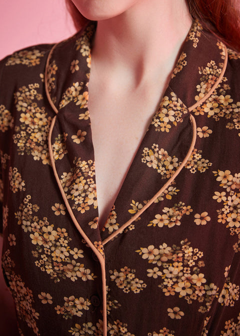 Close-up of rounded collar with contrast piping on brown floral viscose dress