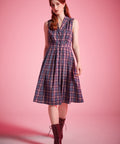 Woman wearing sleeveless plaid dress styled with lace-up ankle boots