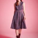 Woman wearing sleeveless plaid dress styled with lace-up ankle boots