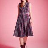 Woman wearing sleeveless plaid dress styled with lace-up ankle boots