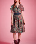 Woman wearing vintage-inspired floral fit-and-flare dress styled with lace-up boots