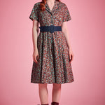 Woman wearing vintage-inspired floral fit-and-flare dress styled with lace-up boots