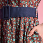 Side pocket and removable navy buckle belt detail on floral cotton dress