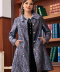 Woman wearing purple A-line brocade coat with oversized rounded collar and side pockets
