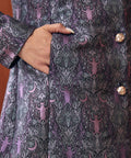 Detail of gothic bat and moon brocade pattern on vintage-inspired women's coat