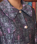 Close-up of women's purple brocade coat with bats crescent moons and botanical motifs