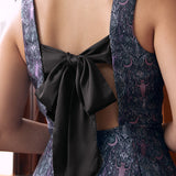 Back view of woman wearing gothic fit and flare dress with open back and oversized black bow