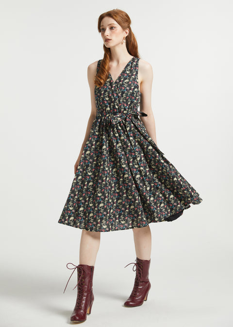 Woman wearing ModCloth Instant Energy Faux-Wrap Dress in Dead Gorgeous featuring a vintage floral skull print, sleeveless V-neck bodice, removable tie belt, and full skirt.