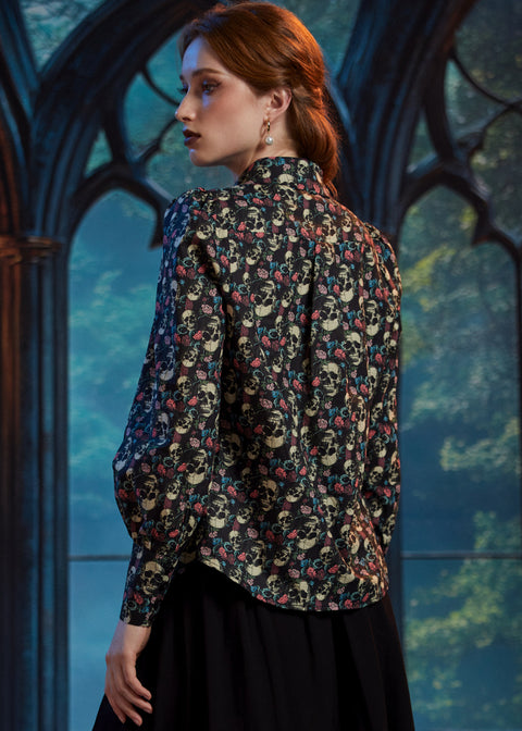 Back view of woman wearing skull floral cotton button-up blouse with curved shirttail hem 