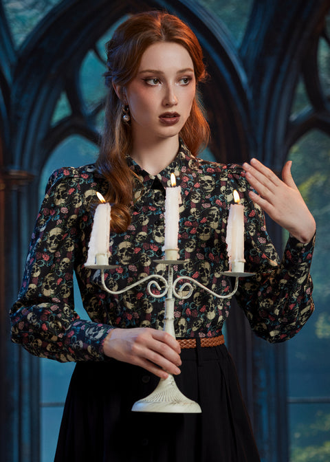 Woman styling gothic skull and floral button-up blouse with candelabra