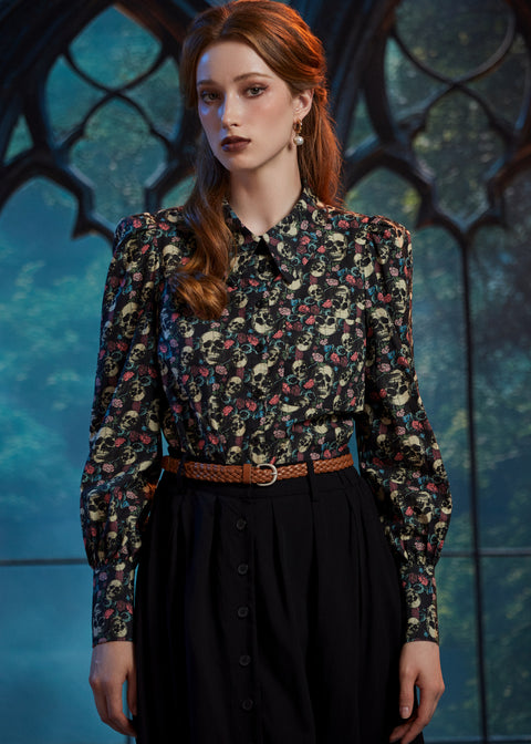 Woman wearing gothic skull floral button-up blouse with pointed collar and puff shoulders