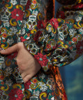 Close-up of the Midnight Soirée Dress Coat sleeve and side seam pocket showcasing the richly woven Memento Mori jacquard fabric.