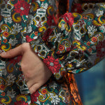 Close-up of the Midnight Soirée Dress Coat sleeve and side seam pocket showcasing the richly woven Memento Mori jacquard fabric.