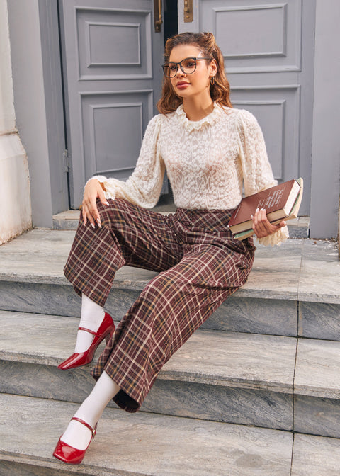 Woman seated wearing brown plaid wide leg culotte pants with side pockets