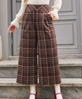 Woman wearing high waisted brown plaid wide leg culotte pants with pockets