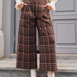 Woman wearing vintage style brown plaid pants with pleated front and pockets