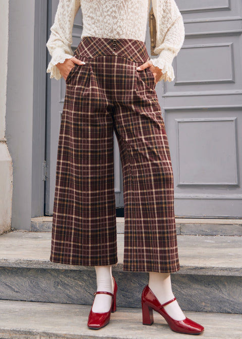 Woman wearing vintage style brown plaid pants with pleated front and pockets
