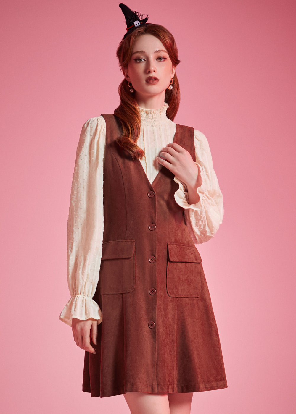Woman wearing 1970s-inspired A-line jumper dress with deep V-neck and front buttons