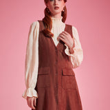 Woman wearing 1970s-inspired A-line jumper dress with deep V-neck and front buttons