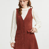 Woman styling rust brown sleeveless jumper dress with cream blouse