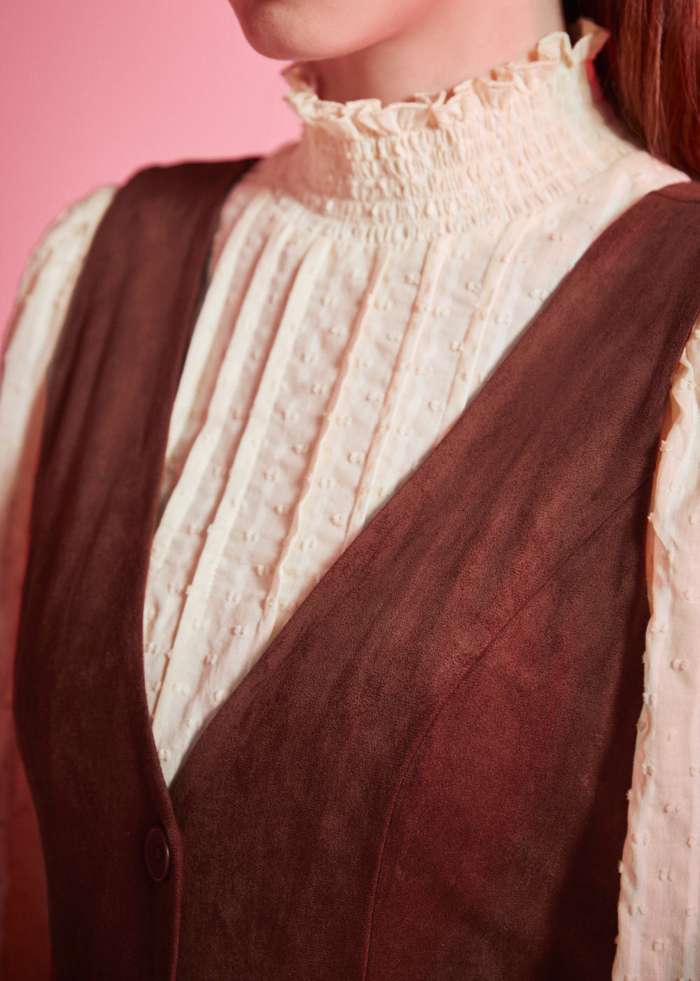 Detail of women's vintage-inspired deep V-neck jumper dress in rust brown