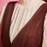 Detail of women's vintage-inspired deep V-neck jumper dress in rust brown