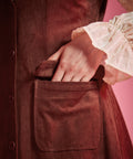 Close-up of women's rust brown button front jumper dress with flap patch pocket
