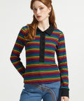 Woman wearing retro rainbow striped cotton polo shirt with long sleeves and contrast black trim