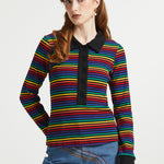 Woman wearing retro rainbow striped cotton polo shirt with long sleeves and contrast black trim