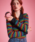 Woman wearing ModCloth rainbow striped long sleeve polo top with black collar and button placket