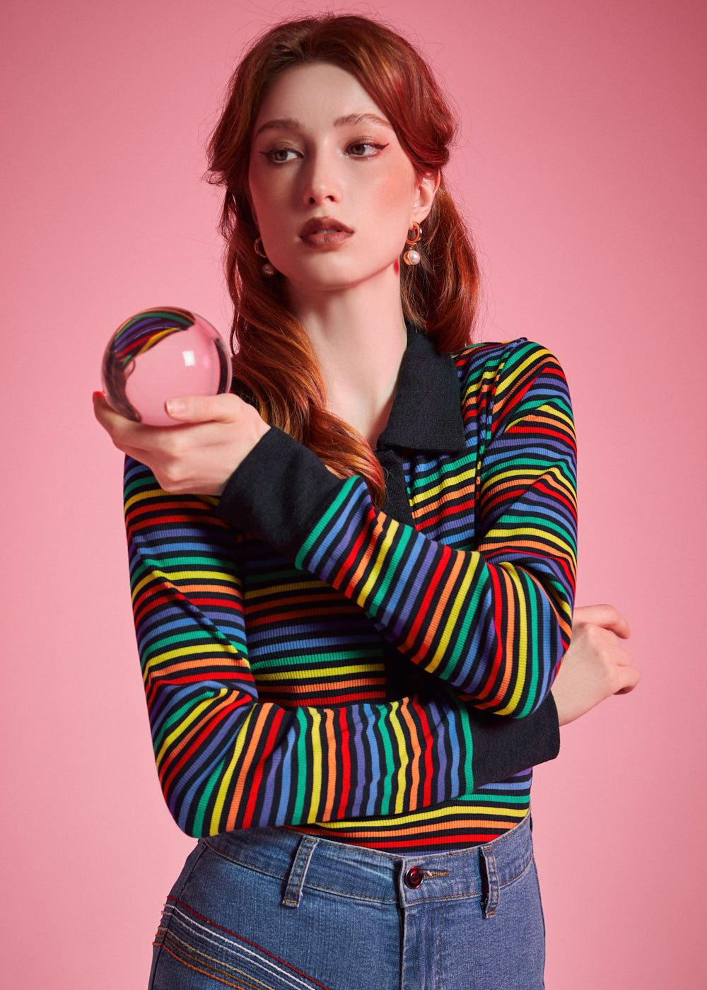 Woman wearing ModCloth rainbow striped long sleeve polo top with black collar and button placket
