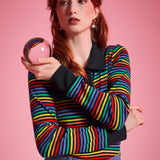 Woman wearing ModCloth rainbow striped long sleeve polo top with black collar and button placket