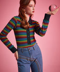 Women's fitted rainbow stripe polo top with long sleeves, black cuffs, and button-front placket