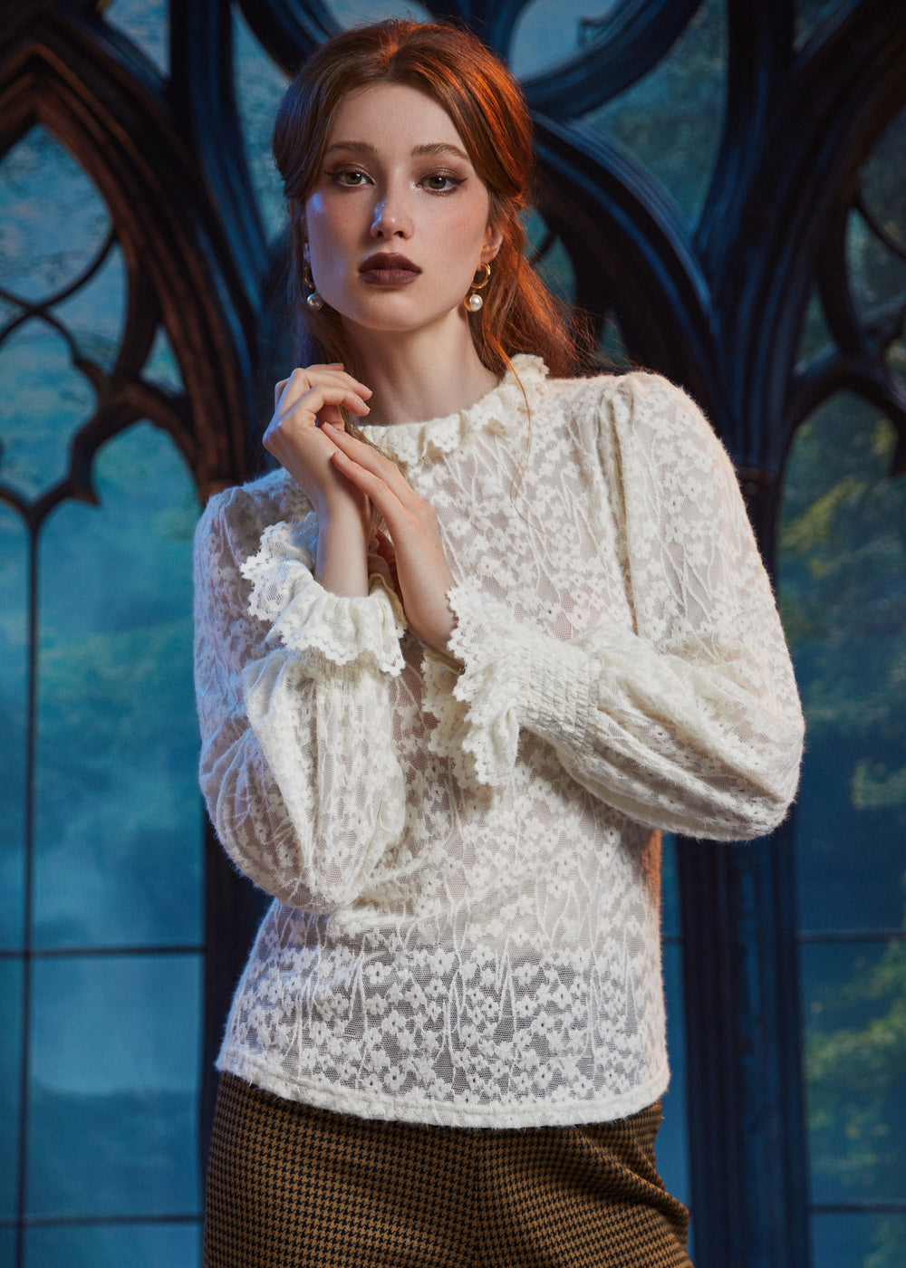 Woman wearing ivory floral lace blouse with ruffled high neckline and long sleeves