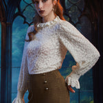 Woman wearing ivory lace ruffle blouse styled with high-waisted houndstooth pants