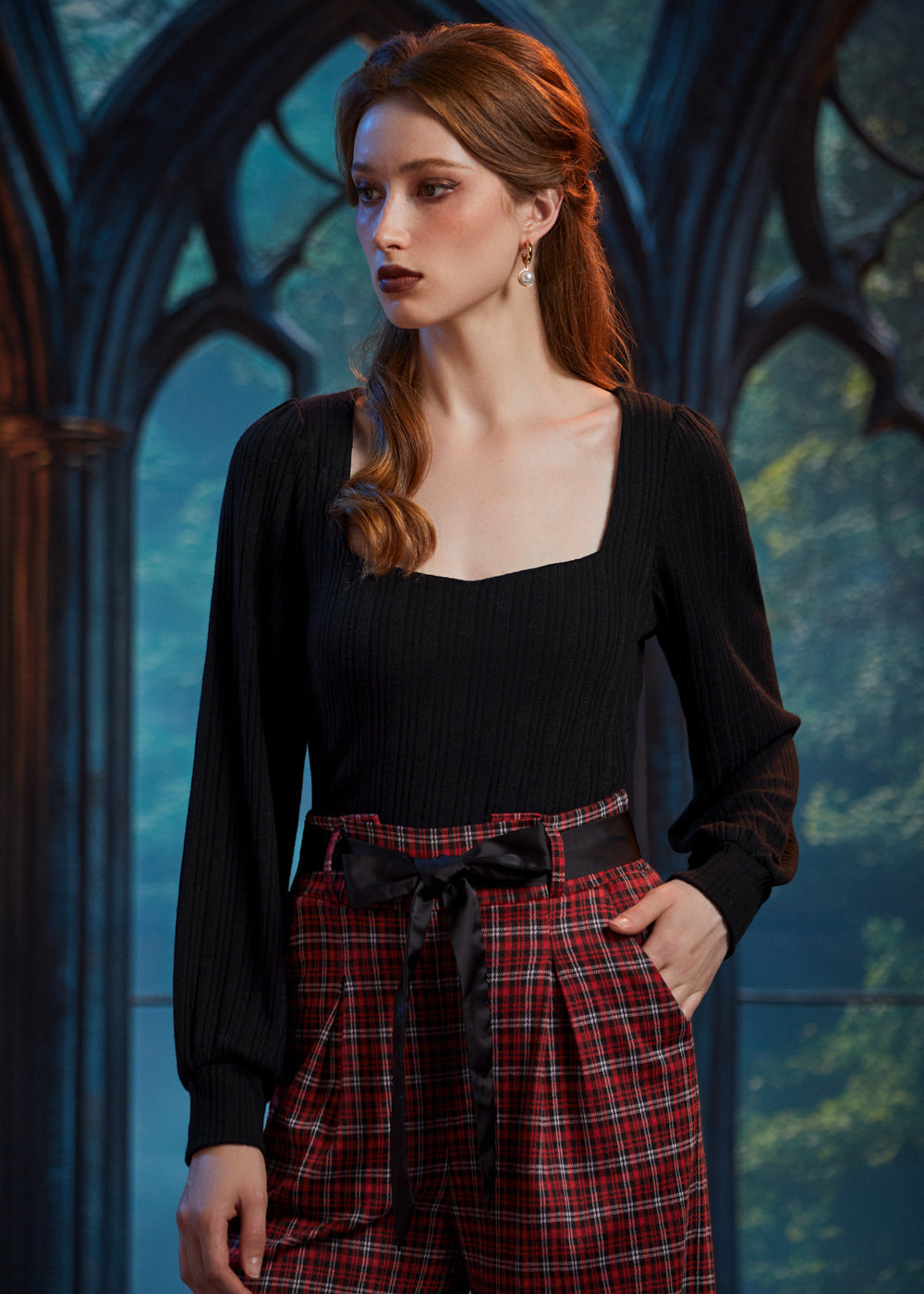 Woman wearing black ribbed knit square neck top with balloon sleeves and high-waisted plaid trousers