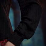 Close-up of black ribbed knit balloon sleeve showing the voluminous shape and wide fitted cuff