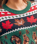 Close-up of a festive knit sweater with a green crew neck and a holiday pattern featuring red maple leaves, acorns, and brown squirrels.