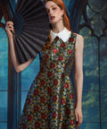 Woman wearing ModCloth Forever Remembered Dress in Memento Mori featuring a sleeveless fit-and-flare silhouette, ruffled Peter Pan collar, and textured brocade fabric.