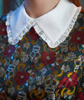 Close-up of the ruffled Peter Pan collar on the Forever Remembered Dress showcasing the richly textured floral brocade.