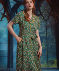 Woman wearing button-front shirt dress with pockets, removable belt, and woodland frog print.