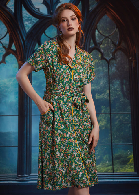 Woman wearing button-front shirt dress with pockets, removable belt, and woodland frog print.