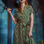 Woman wearing ModCloth Going Out And About button-front midi dress in Toadally Bewitched frog and mushroom print with removable tie belt.