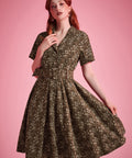 Woman wearing olive floral fit-and-flare dress with flowing full skirt