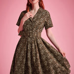 Woman wearing olive floral fit-and-flare dress with flowing full skirt