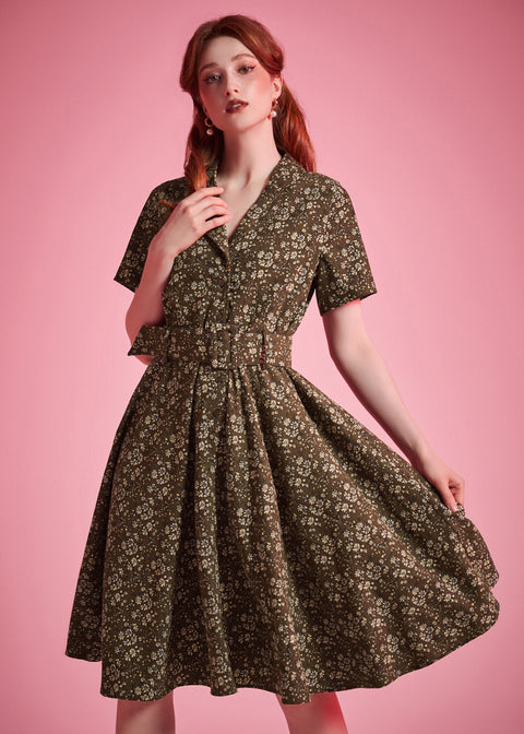 Woman wearing olive floral fit-and-flare dress with flowing full skirt